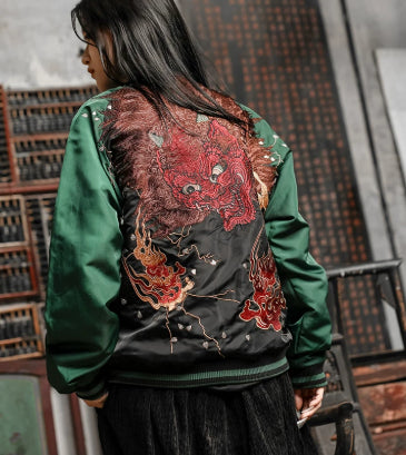 Person wearing a green jacket with red dragon embroidery in an indoor setting