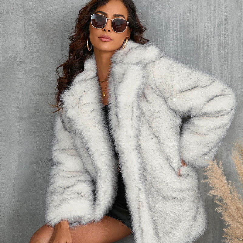 Woman wearing a light gray fur coat against a neutral background