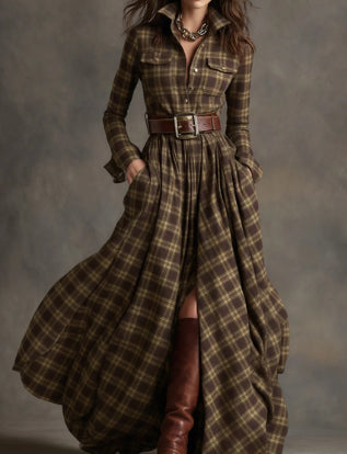 Woman wearing a long plaid dress with a belt against a gray background